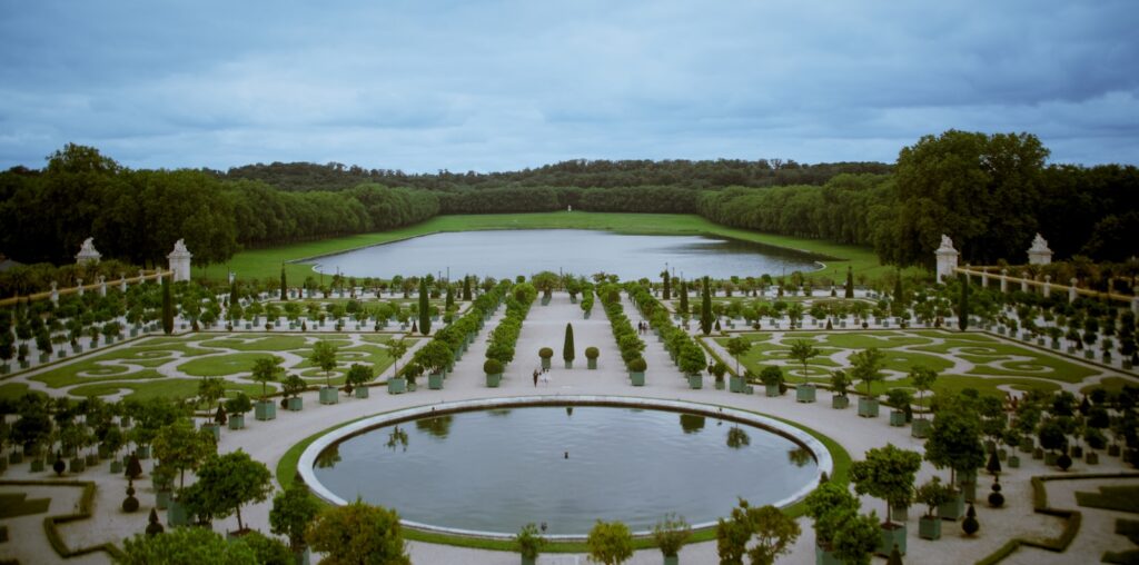 A large garden with a pond surrounded by trees